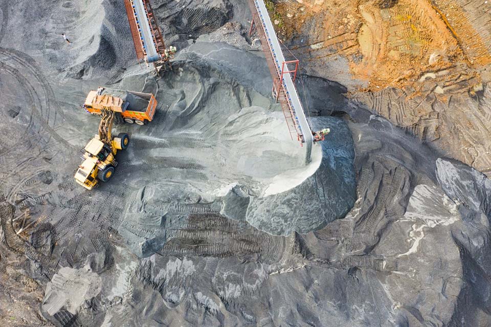 engins et camions à coté d'une ligne d'extraction dans une mine