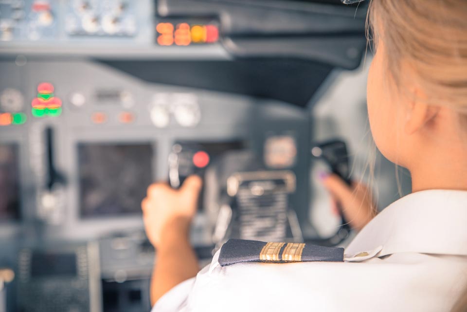 une femme pilote dans un cockpit tenant le manche d'un avion